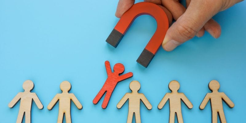 Talent employee attracting and recruitment. Red figure and magnet.